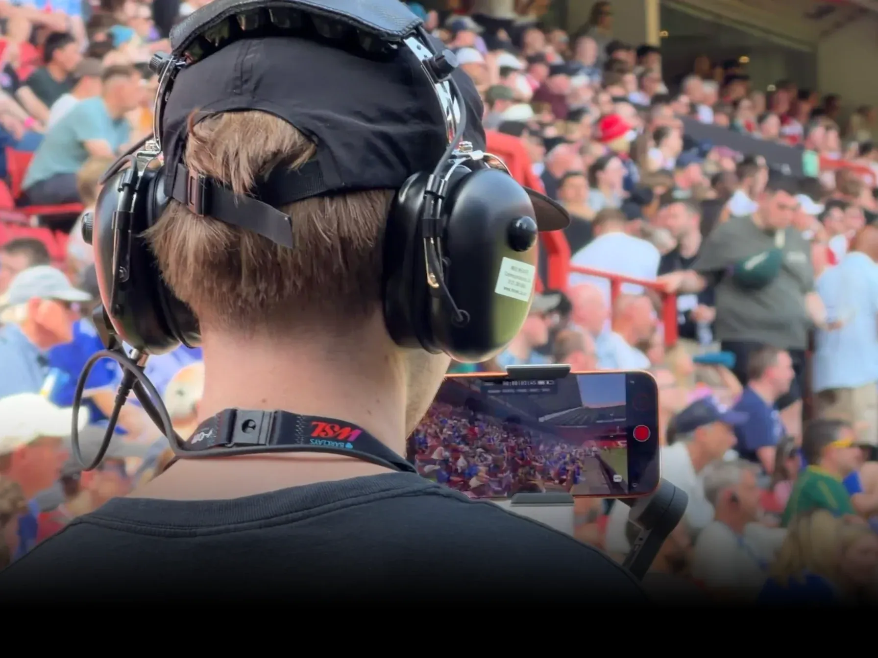 Camera operator films a football match with an iPhone