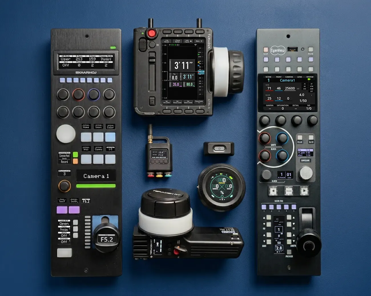 Camera control panels, focus controllers and accessories arranged on a blue surface